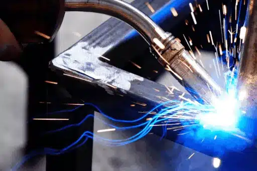 Close-up of welding torch creating a shower of sparks as a worker joins metal pieces