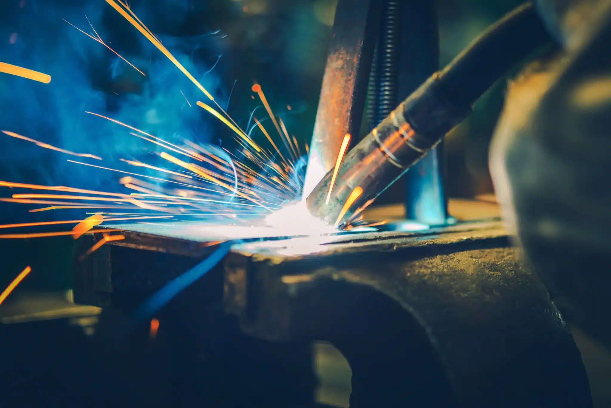 Bright sparks flying as a worker welds a metal piece up close